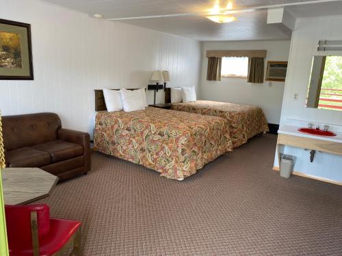 a hotel room with a bed and a couch at Cedars Motel in Ironwood