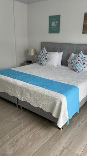 Una cama grande con sábanas azules y almohadas. en Hotel Mar de Corales By CAJASAI en San Andrés