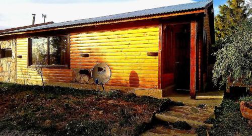 eine kleine Holzhütte mit einer offenen Tür in der Unterkunft Cabaña Onty in El Calafate