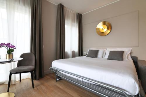 a bedroom with a bed and a table and a chair at PRESTIGE BOUTIQUE APARTHOTEL - Piazza Duomo View in Milan