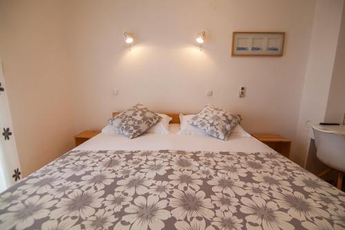 a bedroom with a bed with a gray and white comforter at Kos Apartments in Bol
