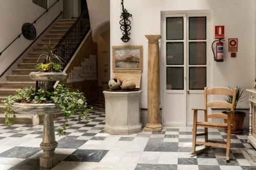 a lobby with a staircase and a teddy bear sitting in a planter at Hotel Alquimia Cadiz in Cádiz