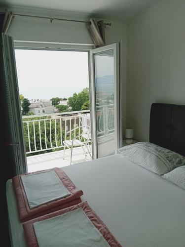 a bedroom with a bed and a large window with a balcony at Tonka Apartments in Gradac