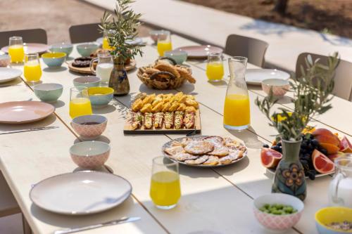 a table with breakfast foods and orange juice at Villa Aura Loutraki in Loutraki