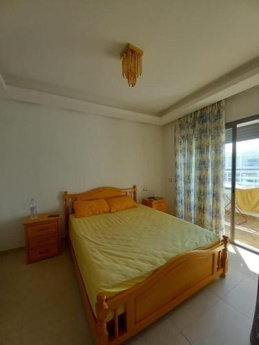 - une chambre avec un lit en bois et une fenêtre dans l'établissement Bel Appartement à Mansbay, à Minaret de Mansuria