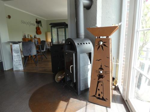 a wood stove in a living room with a table at NordseeResort Hotel & Suite Arche Noah in Horumersiel
