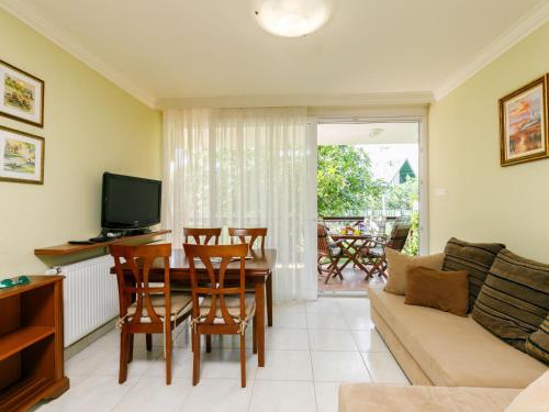 a living room with a couch and a table with chairs at Apartment Figo by Interhome in Balatonőszöd