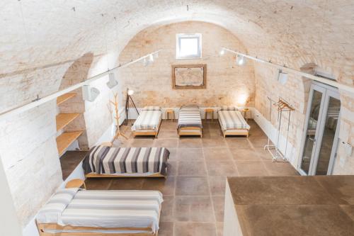 a room with couches and stairs in a building at Ostello dei Giardini di Pomona in Cisternino