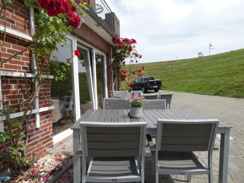 a wooden table and chairs on a patio at NordseeResort Hotel & Suite Arche Noah in Horumersiel