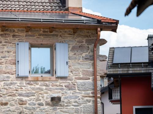 a window on the side of a stone building with solar panels at Holiday Home Casa Maria by Interhome in Spert