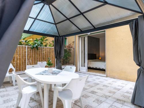 eine Terrasse mit einem weißen Tisch und weißen Stühlen in der Unterkunft Apartment Giardino al Mare by Interhome in Sanremo