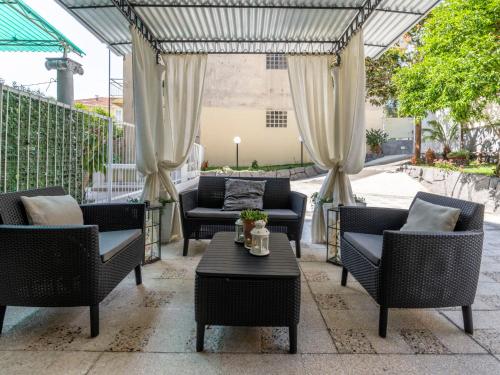 eine Außenterrasse mit Stühlen, einem Tisch und einer Markise in der Unterkunft Apartment Giardino al Mare by Interhome in Sanremo
