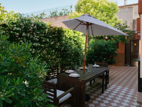 a wooden table with an umbrella on a patio at Ca' Mazzega in Murano