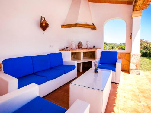a living room with blue and white furniture and a table at Villa La Esquina by Interhome in Jávea