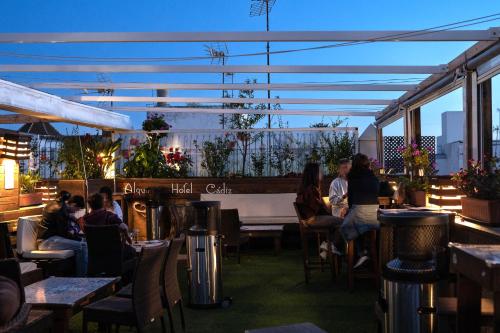 un groupe de personnes assises à table dans un restaurant dans l'établissement Hotel Alquimia Cadiz, à Cadix