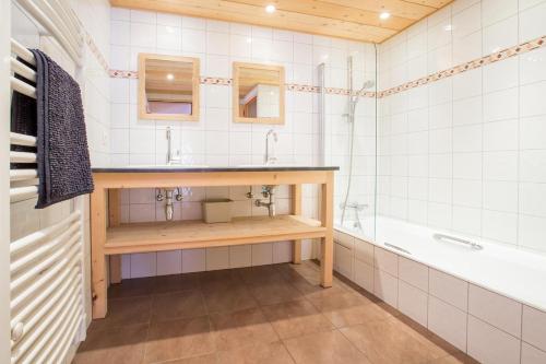 a bathroom with a sink and a tub at Appartement les murailles in Morzine