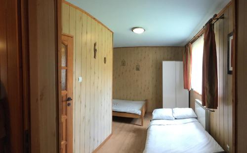 ŻabnicaにあるAgroturystyka Pod Wierchamiのベッド2台と窓が備わる小さな客室です。