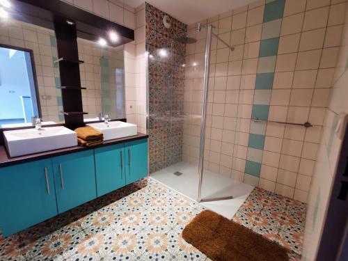 a bathroom with two sinks and a shower at Bel appartement à quelques pas du lagon - Terre Sainte LA RÉUNION in Saint-Pierre