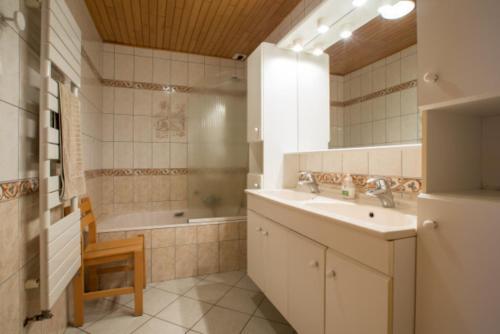 a bathroom with a sink and a tub and a mirror at Chalet Poupette in Morzine