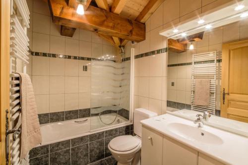 a bathroom with a toilet and a tub and a sink at Rare Chalet 30 Personnes in Morzine