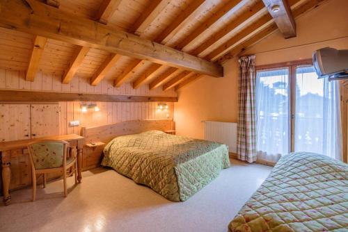 um quarto com uma cama, uma secretária e uma mesa em Rare Chalet 30 Personnes em Morzine
