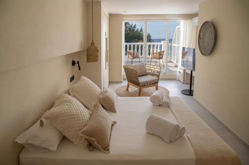 a bedroom with a bed with a view of the ocean at Boho Suites Formentera in Es Pujols