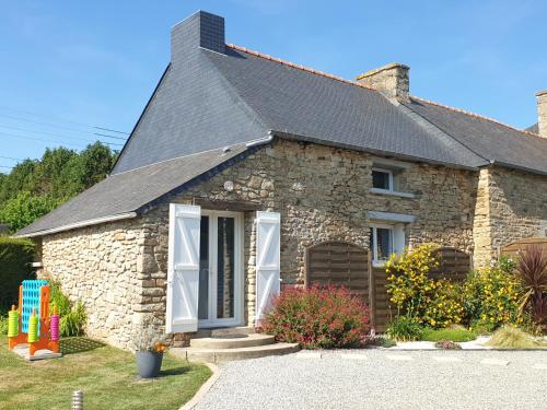 a stone house with a gray roof at Charming traditional 2-Bed Cottage near Plemet in Plémet