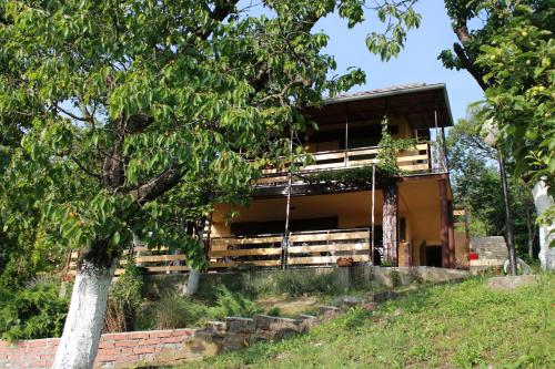 un edificio con un albero di fronte di Marley kuca za odmor a Bešenovački Prnjavor