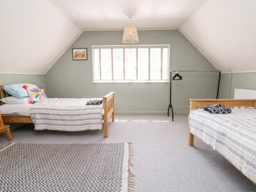 a attic bedroom with two beds and a window at Melbecks in Abergele