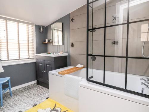 a bathroom with a tub and a sink at Melbecks in Abergele