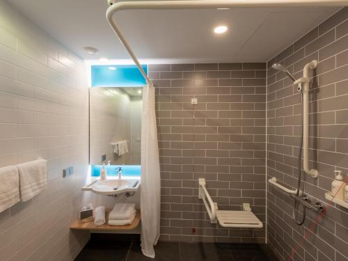 a bathroom with a sink and a shower at Holiday Inn Express - Hamburg South A7-AS42 by IHG in Egestorf