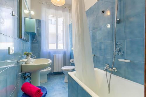 La salle de bains bleue est pourvue d'un lavabo et de toilettes. dans l'établissement Appartamento La Pinetina Trilo PT - MyHo Casa, à Tortoreto Lido