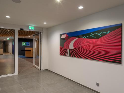 un corridoio dell'ufficio con un grande dipinto sul muro di Holiday Inn Express - Hamburg South A7-AS42, an IHG Hotel a Egestorf