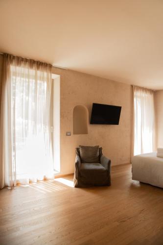 a bedroom with a chair and a bed and a television at Hotel Olivedo in Varenna