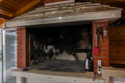 a brick fireplace with a fire place at Kos Apartments in Bol