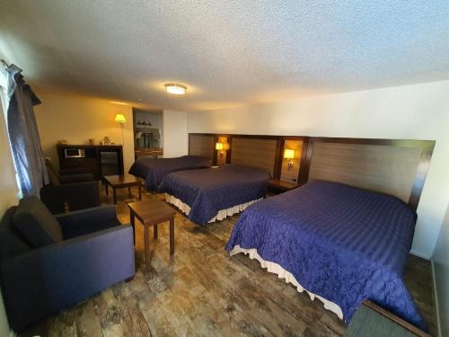 a hotel room with two beds and a couch at Sunrise Motor Inn in Cody
