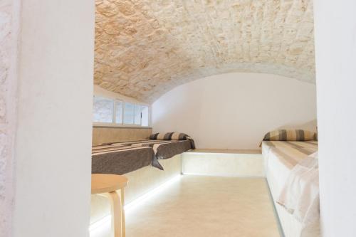 a room with two beds and a table at Ostello dei Giardini di Pomona in Cisternino