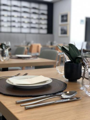 a wooden table with a plate and silverware on it at Villa Rey Spa & Hotel in Vila de Rei