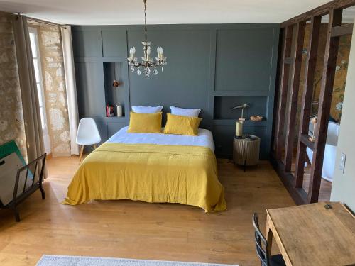 a bedroom with a bed with a yellow bedspread at le secret du chat in Cordes-sur-Ciel