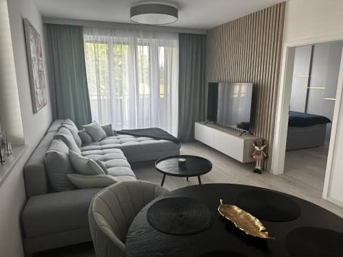 a living room with a couch and a tv at URBAN Haven apartment in Liptovský Mikuláš