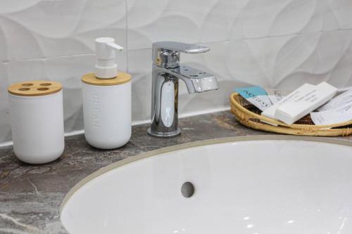 a bathroom sink with two soap bottles and a faucet at Lux Apartment Umai in Astana