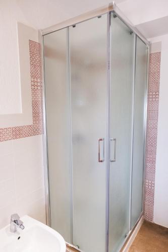 a shower stall in a bathroom with a sink at Ostello dei Giardini di Pomona in Cisternino