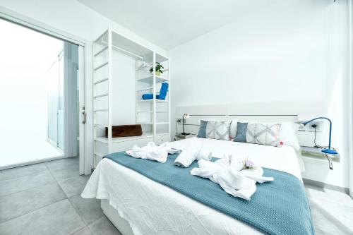 una camera da letto con un letto e asciugamani bianchi di Karma Famara 1 a 25m del mar a Famara