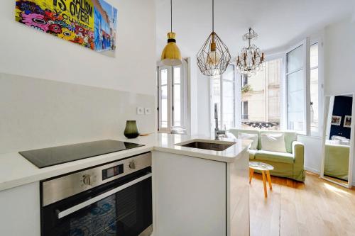 - une cuisine blanche avec évier et cuisinière dans l'établissement Appartement 16th Tour Eiffel - Central Paris, à Paris