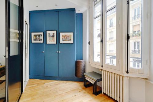 une porte bleue dans une pièce avec quelques fenêtres dans l'établissement Appartement 16th Tour Eiffel - Central Paris, à Paris