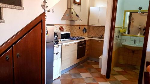 a small kitchen with a sink and a refrigerator at Villetta Rossi in Nebida