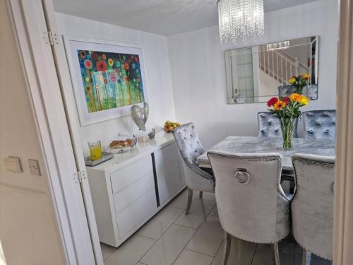a kitchen with a table and chairs and a vase of flowers at Silverstone Stays in Wootton