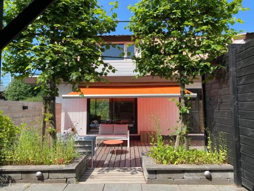 a garden with a patio and a house at Unieke woonark met privétuin en free parking. in Rotterdam