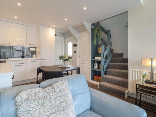 a living room with a blue couch and a kitchen at Moelwyn 57D South Snowdon Wharf in Porthmadog