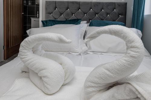 two swans made out of towels on a bed at Clydfan in Holyhead